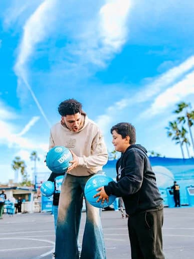 A guest and a young fan practice with AT&T basketballs on the court