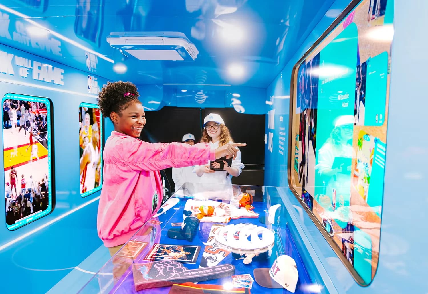 Inside the AT&T Dunk Bus in Miami, a young fan points at the Slam Dunk Wall of Fame